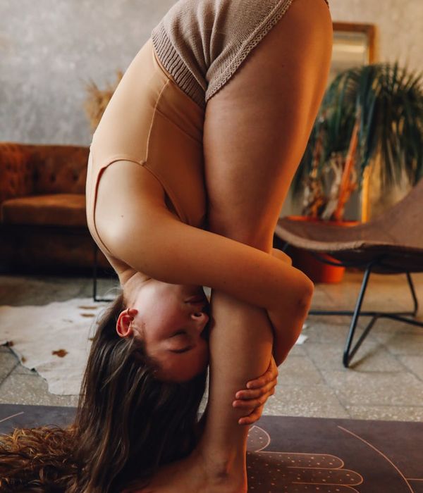 Person holding a yoga pose, amber light highlighting the spine.